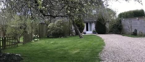Un jardin bien entretenu, avec un chemin de gravier menant à une maison.
