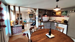 Una cocina acogedora con una mesa de comedor, sillas y una chimenea de ladrillo.