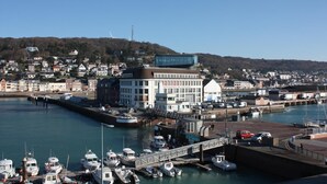 A marina with boats docked, a bridge, and buildings including a white building with a dome and a sign reading "PECHERIES OF FECAMP". - Gîtes de France® - La Maréchalerie (FECAMP)