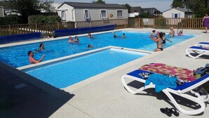 Un área de piscina con varias piscinas y sillas de descanso.