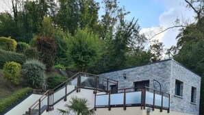 A modern two-story house with a stone facade, a balcony, and a staircase leading to the upper floor. - Gîtes de France® - At the crossroads (BERNEVAL LE GRAND)