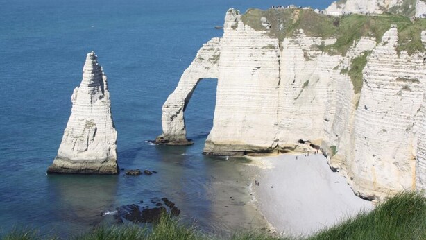 A coastal landscape with prominent white cliffs and a clear view of the sea.