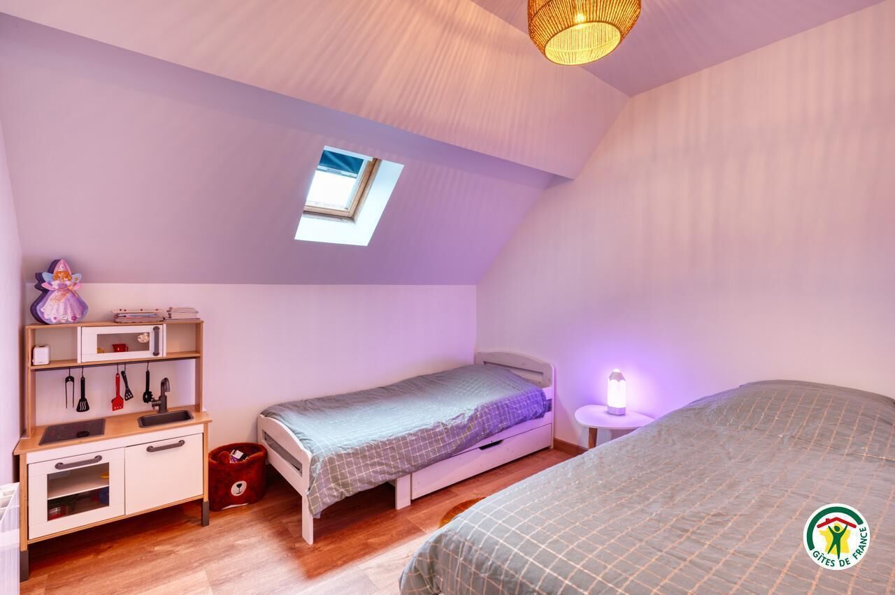 Quarto com beliche, uma escrivaninha pequena e uma janela.