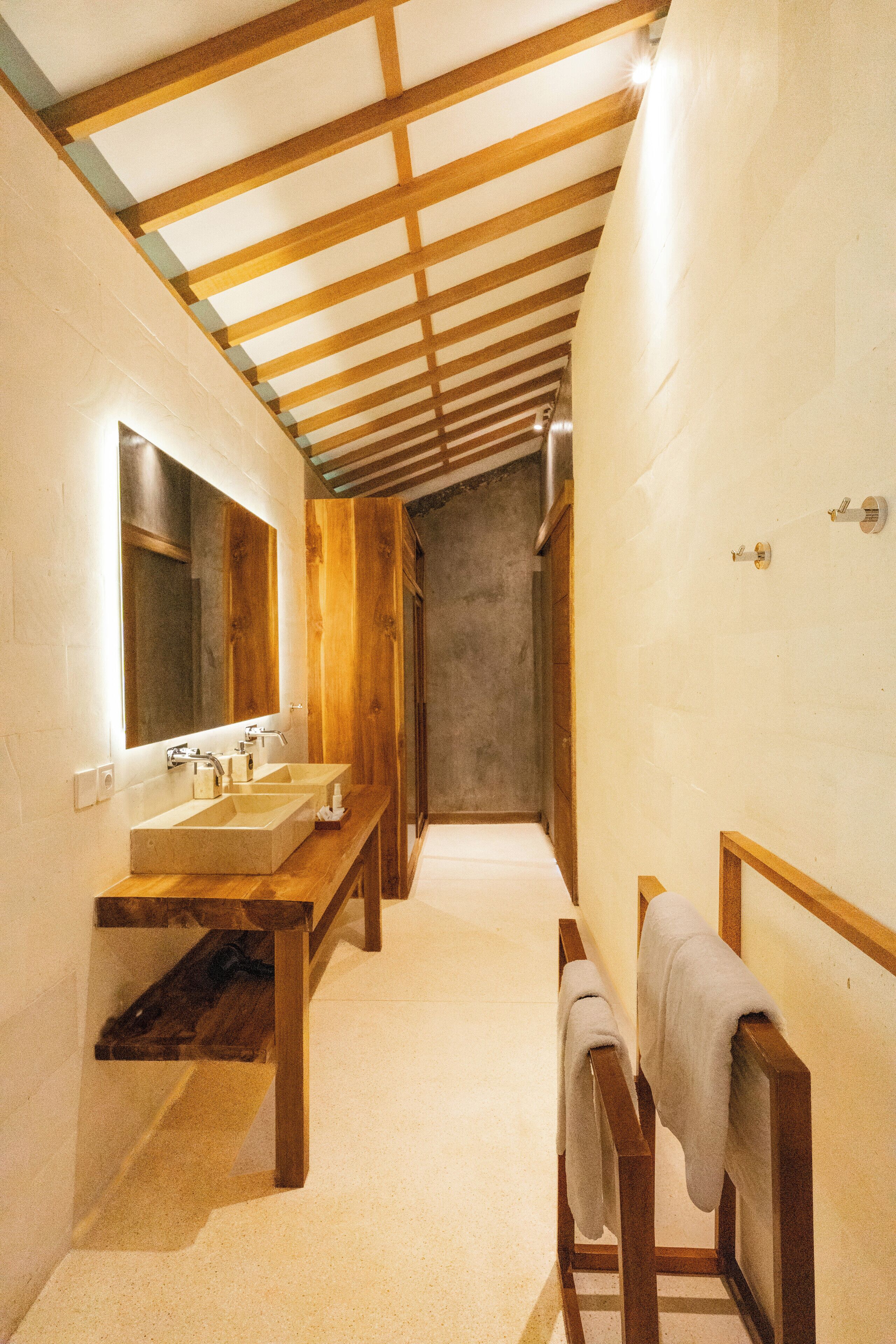 Un intérieur en bois avec un long banc, un évier et un miroir.