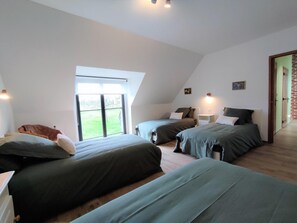 Un dormitorio con dos camas, un ventanal grande y una puerta que da a un balcón.