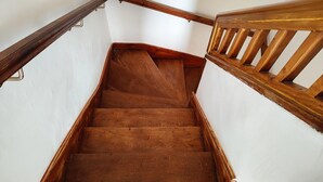 Eine Holztreppe mit Geländern auf beiden Seiten, die zu einer oberen Etage führt.