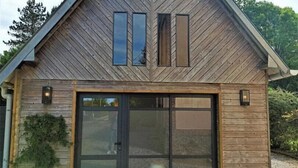 A modern wooden house with a large sliding glass door, a sloped roof, and two windows. - Gîtes de France® - du Mesnil (ECTOT L'AUBER)