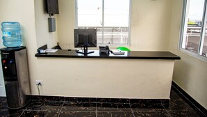 A reception desk with a water dispenser, a computer, and a clock on the wall. - Spacious room (queen size bed) in a hotel in Punta Cana (Punta Cana)