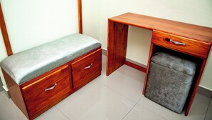 A wooden desk with drawers and a cushioned seat, positioned against a plain wall. - Spacious room (queen size bed) in a hotel in Punta Cana (Punta Cana)