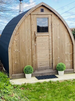 A wooden shed with a sloped roof, a door, and a small window. - Gîtes de France® - The Gateway to Aval   (VILLAINVILLE)