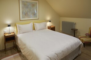 Relax in this cozy space with a large bed, two bedside tables, and a comfortable chair.
