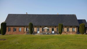 A large, two-story building with a dark roof and a symmetrical facade.