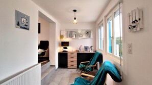 Una cocina moderna con zona de comedor, un ventanal y un espejo sobre la encimera.