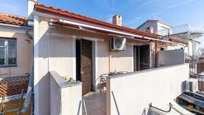 A residential building with a red-tiled roof, a white exterior, and a small balcony with a metal railing. - Cozy apartment in Jadranovo with WiFi (Jadranovo)