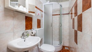 A bathroom with a sink, toilet, and a glass-enclosed shower stall. - Cozy apartment in Jadranovo with WiFi (Jadranovo)