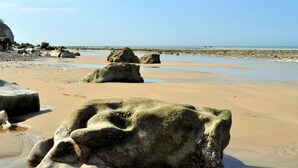 A beach with large rocks and a sandy shore. - Gîtes de France® - Le Neuf-Moulin (SAINT CRESPIN)