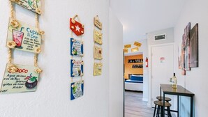 A hallway with a dining area featuring a table and stools, a fire extinguisher, and a door with a sign.