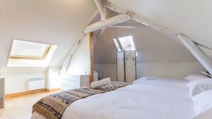 Un dormitorio con una cama grande, una ventana y un radiador.