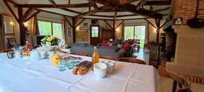 Un coin repas avec une table mise pour le repas, un canapé et une cheminée.