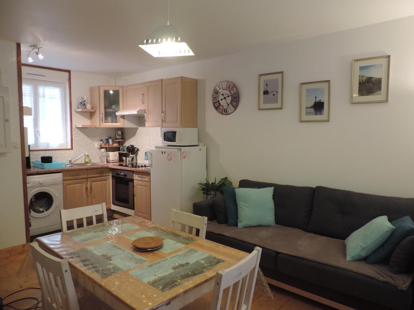 Un ambiente compatto con angolo cottura, zona pranzo e salotto.