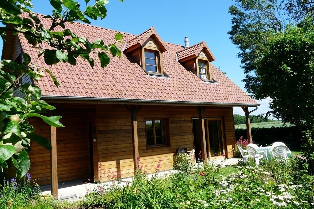 A wooden house with a sloped roof and two dormer windows.