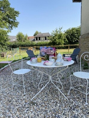 Relax in style with a round table set amidst lush surroundings and comfortable seating for four.
