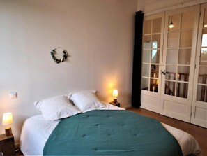 Restful retreat with a neatly made bed, bedside lamps, and a beautiful view.