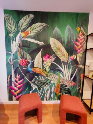 Relax in a tropical oasis with a vibrant mural and comfortable seating area.
