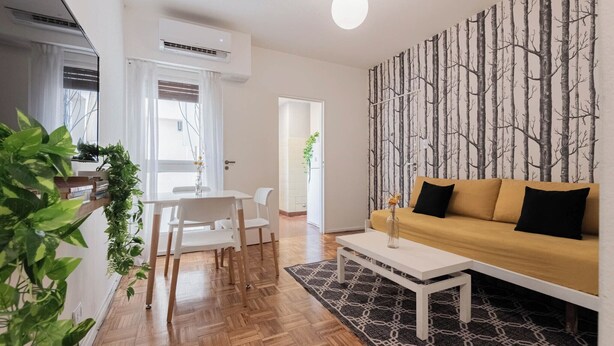 A modern living room with a sofa, coffee table, and dining area. - MOT Borges 2200 (Buenos Aires)