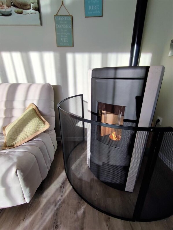 Un salón acogedor con una chimenea moderna, un sofá confortable y una pared decorativa con citas inspiradoras.