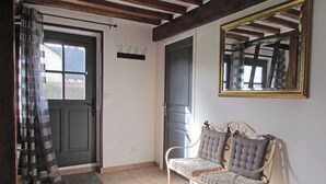 A room with a bench, a mirror, and a door.