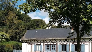 A traditional half-timbered house with a well-maintained lawn and outdoor seating area.