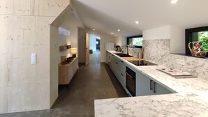 Una cocina moderna con encimera de mármol, armarios de madera y vistas al exterior.