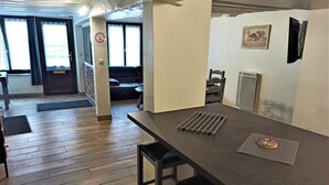 Una cocina moderna con cubierta oscura, dos taburetes de bar y una alfombra pequeña.