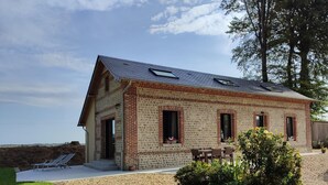 Un bâtiment d’un seul étage, construit en briques, avec un toit en pente et un petit porche.