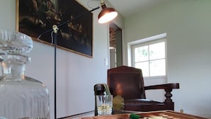 Ein Zimmer mit Billardtisch, einem Gemälde an der Wand und einem Sessel.