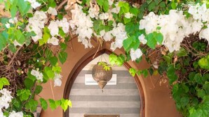 A room with a bed under a decorative archway, a painting on the wall, and a hanging light fixture. - Luxury villa, pool, spa and 5-star sercice (Makinat Sridi)