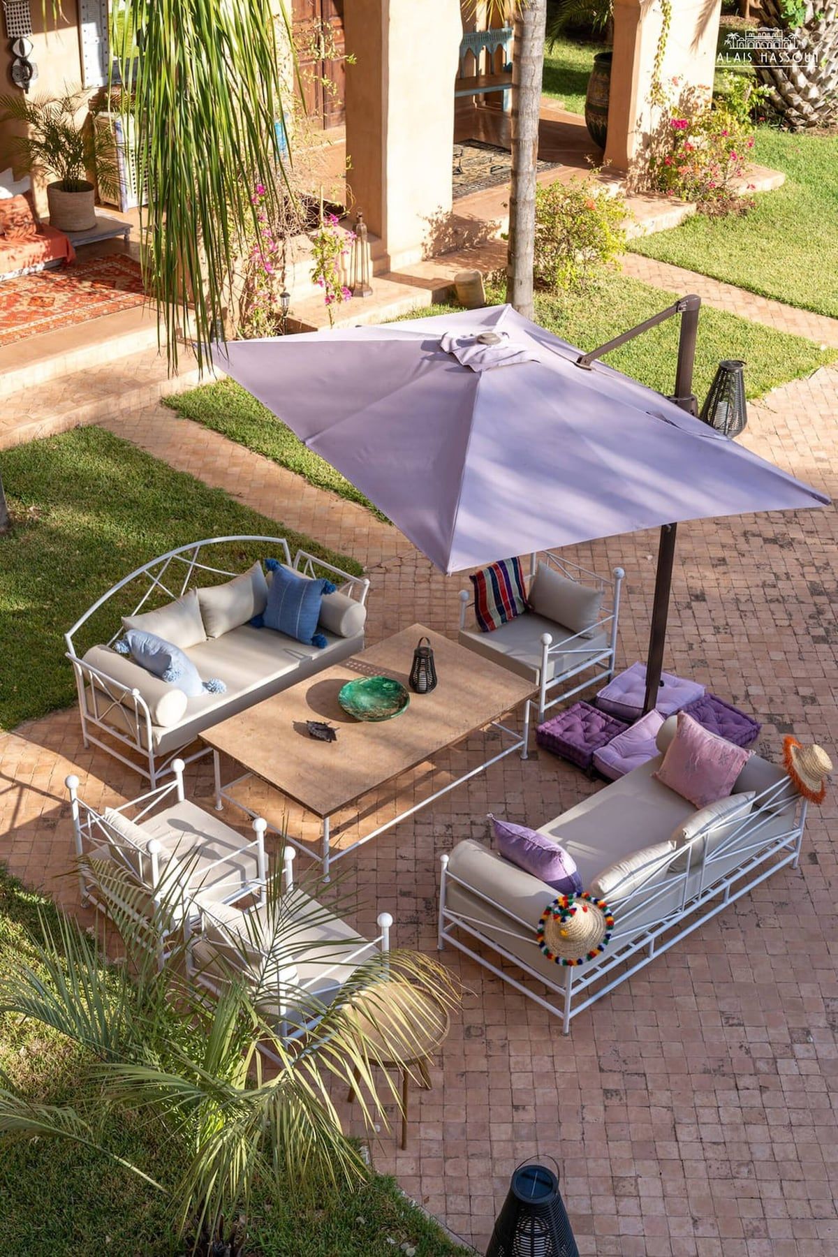 An outdoor patio with a seating area featuring a table, chairs, and a large umbrella.