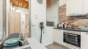 Une cuisine moderne dotée d’un four encastré, d’une cuisinière à gaz et d’un dosseret en briques.