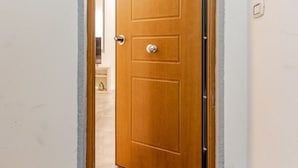 Une porte en bois, dotée d’une poignée et d’un bouton de porte, qui donne sur un espace intérieur.