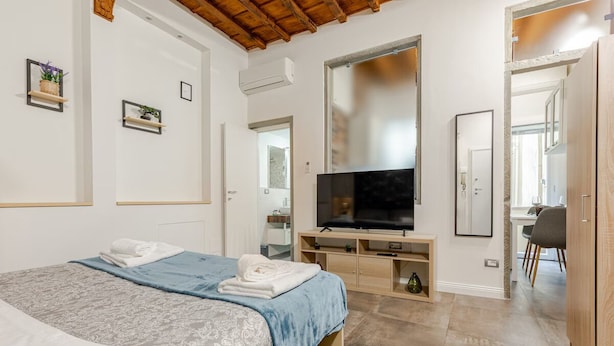 Une chambre moderne avec un lit, une télévision et un espace bureau.