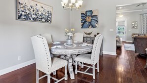 A dining room with a round table, four chairs, and a chandelier. - Southern Comfort! Charming 3 Bedroom Between Baton Rouge and New Orleans (Geismar)