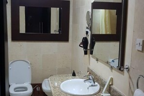 Guests can enjoy a functional bathroom with a toilet, sink, and shower area.