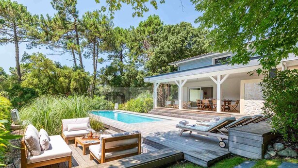 A modern house with a pool, outdoor furniture, and a covered patio area. - CHARMING VILLA WITH HEATED POOL OVERLOOKING THE GOLF COURSE (SEIGNOSSE)