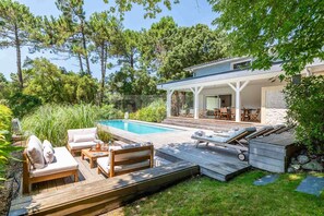 A modern house with a pool, outdoor furniture, and a covered patio area. - CHARMING VILLA WITH HEATED POOL OVERLOOKING THE GOLF COURSE (SEIGNOSSE)
