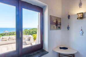 A room with a large window overlooking a scenic view, a small table, and decorative wall art.