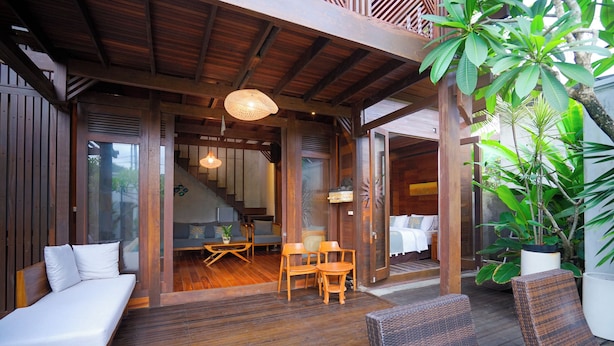 A wooden deck with a sofa, chairs, and a dining table. - Moin Villa Lembongan (Bali)