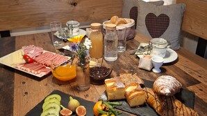 Een ontbijttafel met diverse soorten eten, zoals fruit, gebak en drankjes.