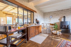 Una cucina rustica con mobili in legno, un grande specchio, un muro in pietra e un camino.
