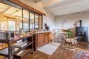 Une cuisine rustique avec des meubles en bois, un grand miroir, un mur en pierre et une cheminée.